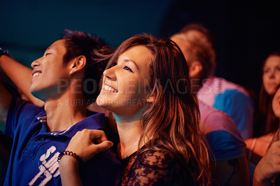 Buy stock photo A young couple enjoying a performance at a festival together