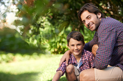 Buy stock photo Shot of a loving father and son bonding in a garden setting