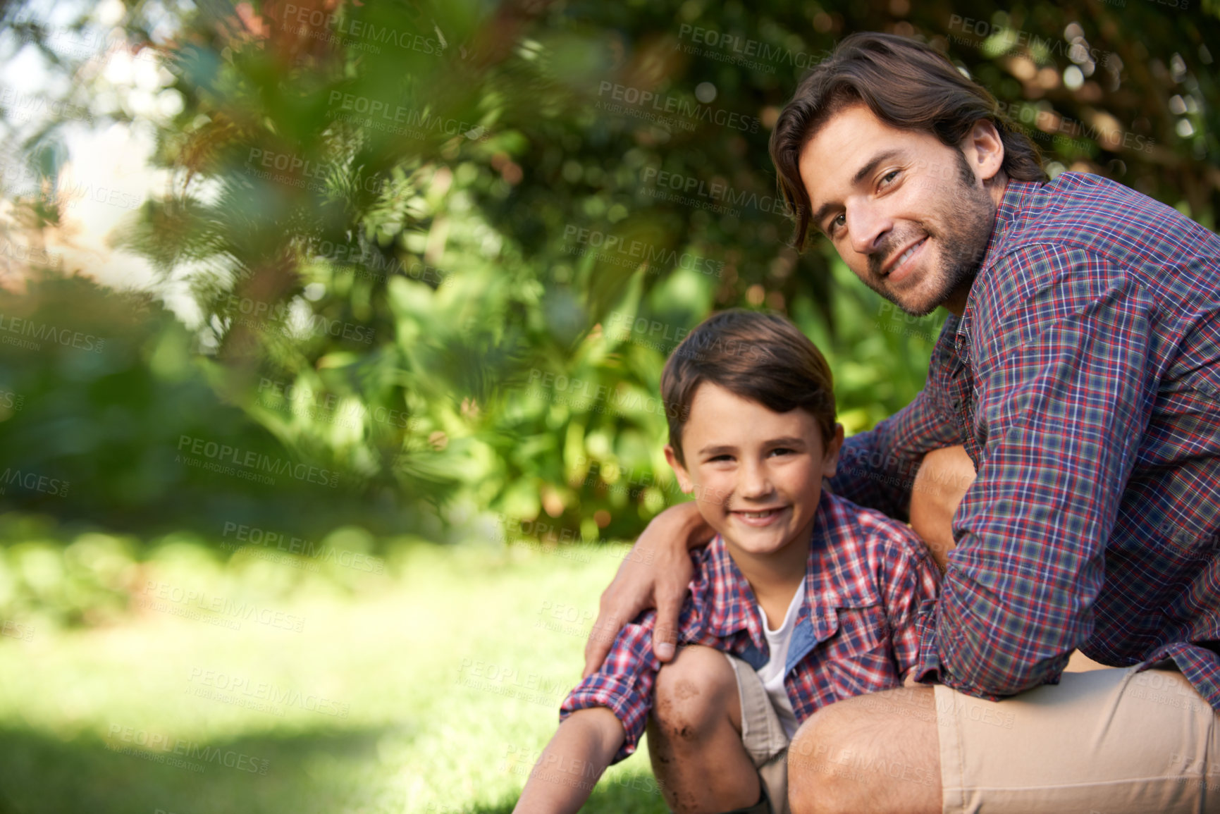 Buy stock photo Shot of a loving father and son bonding in a garden setting