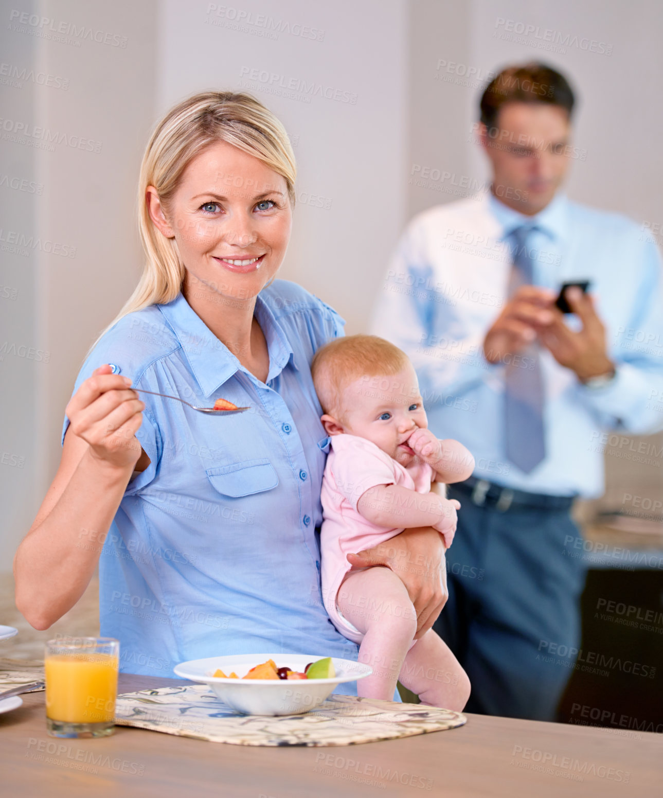 Buy stock photo Mother, healthy breakfast and baby in home while multitasking and sitting at kitchen table. Working father, woman and child in family house to eat meal and smile in morning for nutrition and portrait