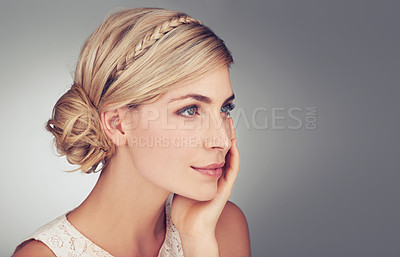 Buy stock photo An attractive young woman thinking while touching her cheek
