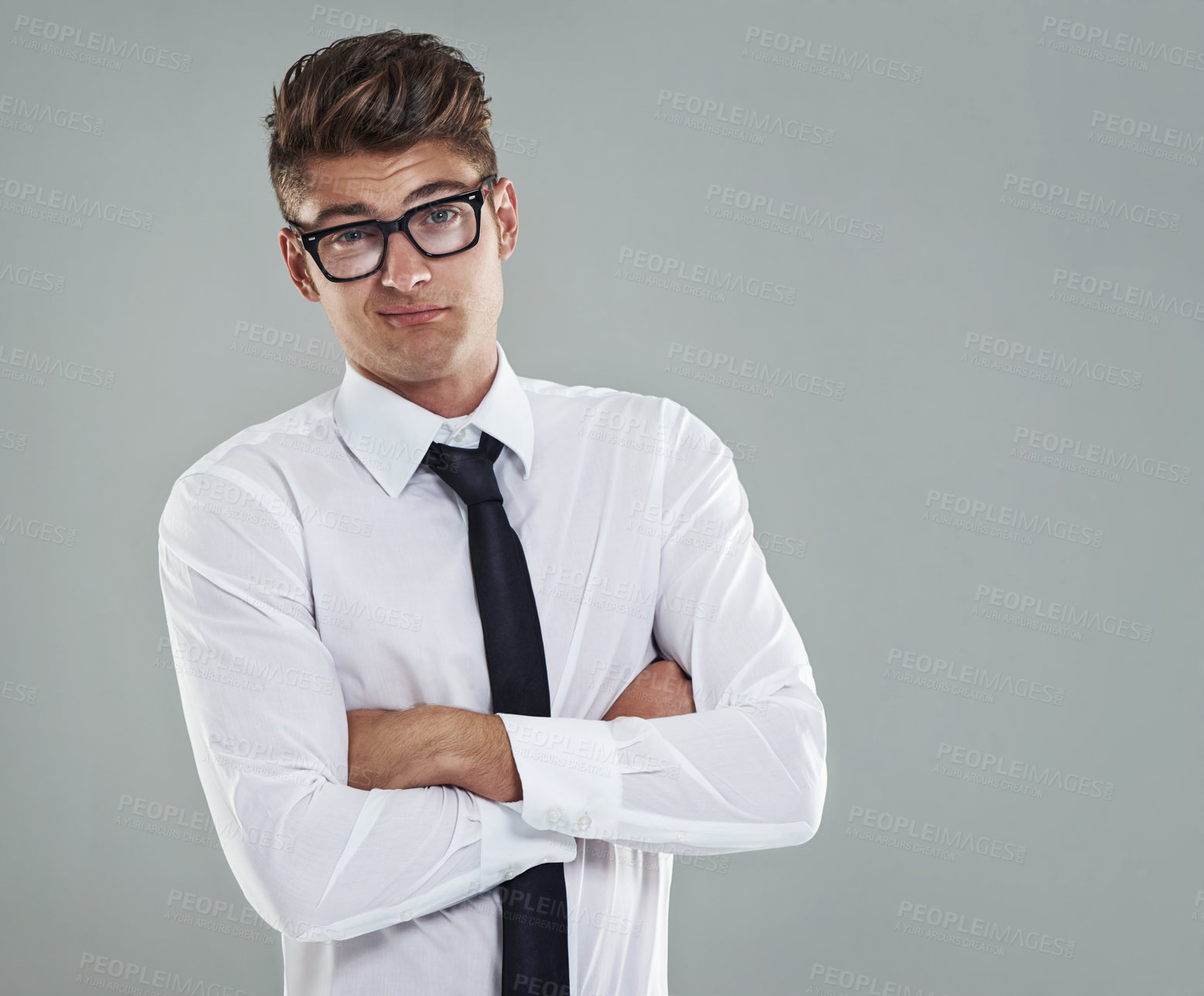 Buy stock photo A cocky young man standing with his arms folded looking at the camera defiantly