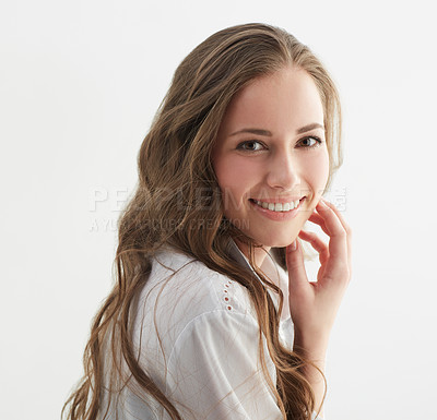 Buy stock photo Studio shot of a young woman looking over her shoulder at the camera