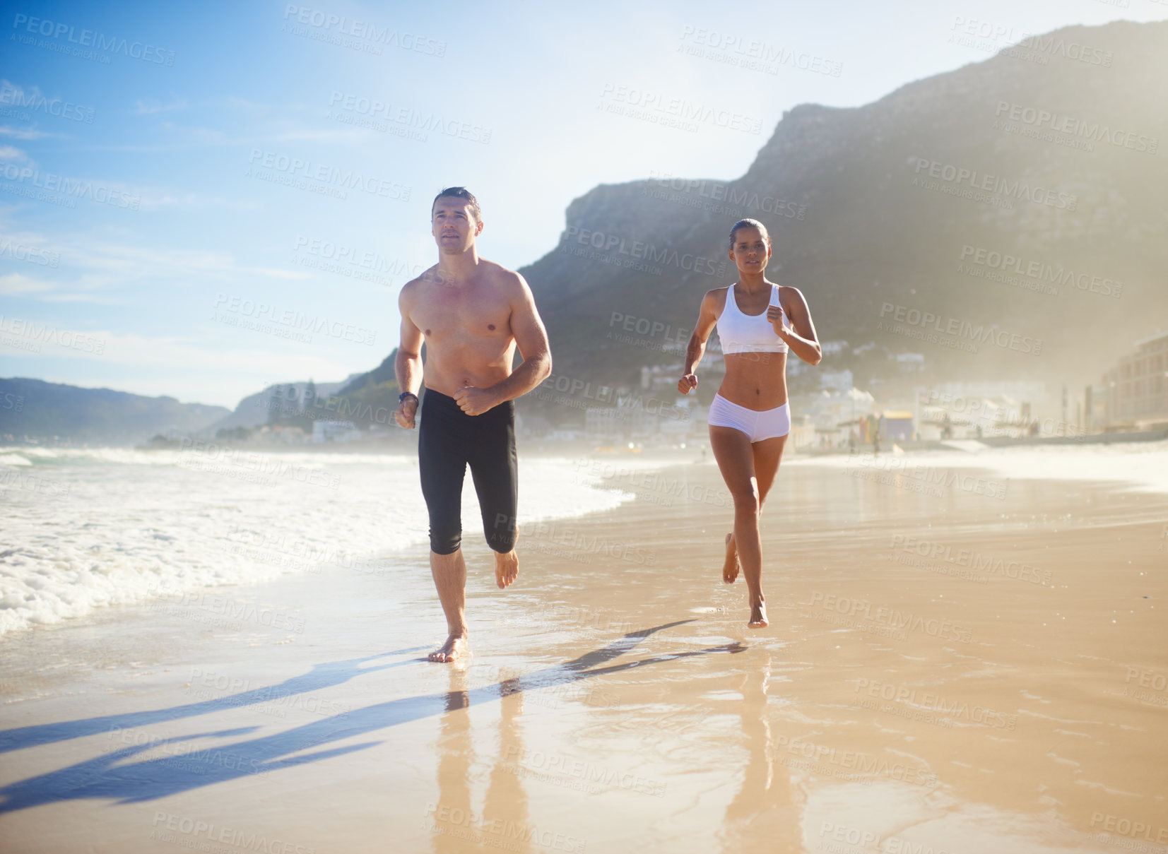 Buy stock photo Full length shot of a couple running along the beach