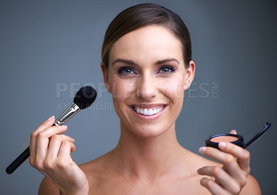 Buy stock photo Portrait of an attractive young woman holding blusher and a brush