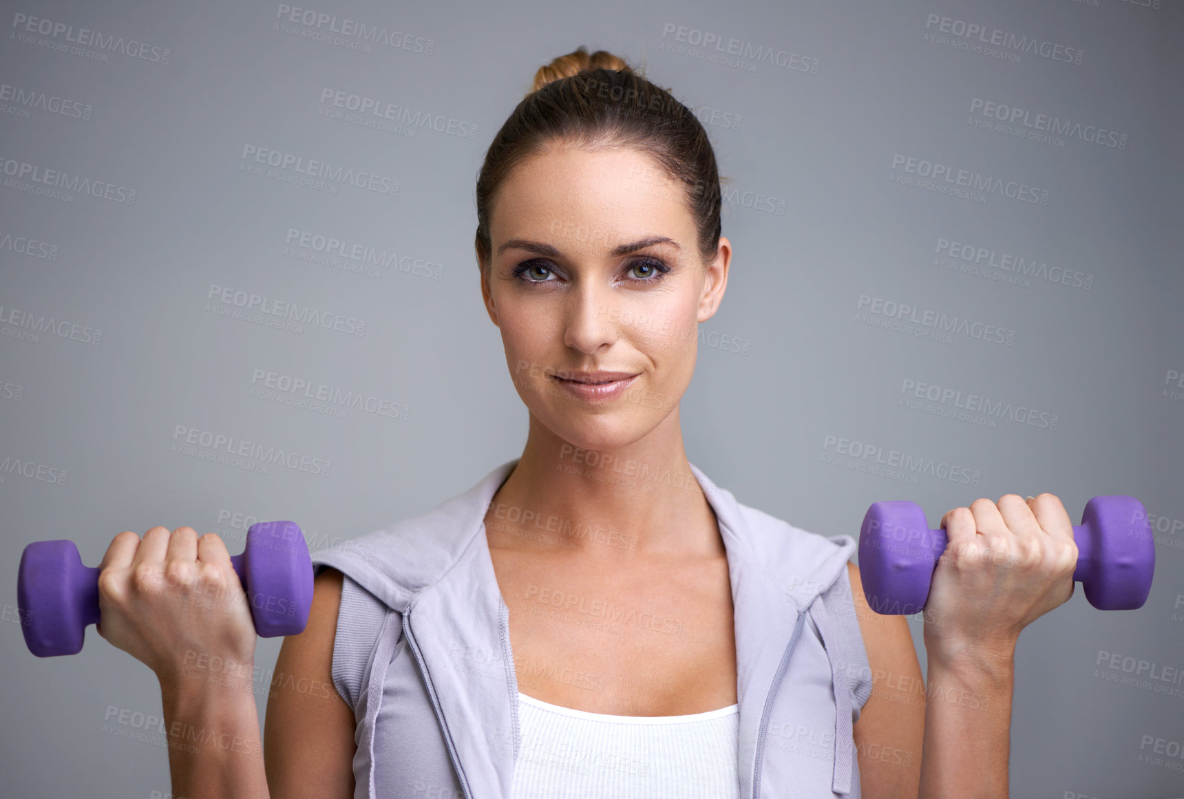 Buy stock photo Happy woman, portrait and dumbbells for weightlifting, fitness or exercise on a gray studio background. Face of active, female person or athlete for strength, muscle gain or workout on mockup space