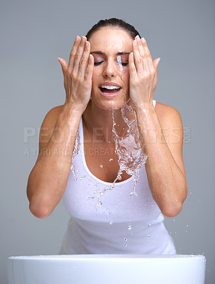 Buy stock photo An attractive young woman washing her face