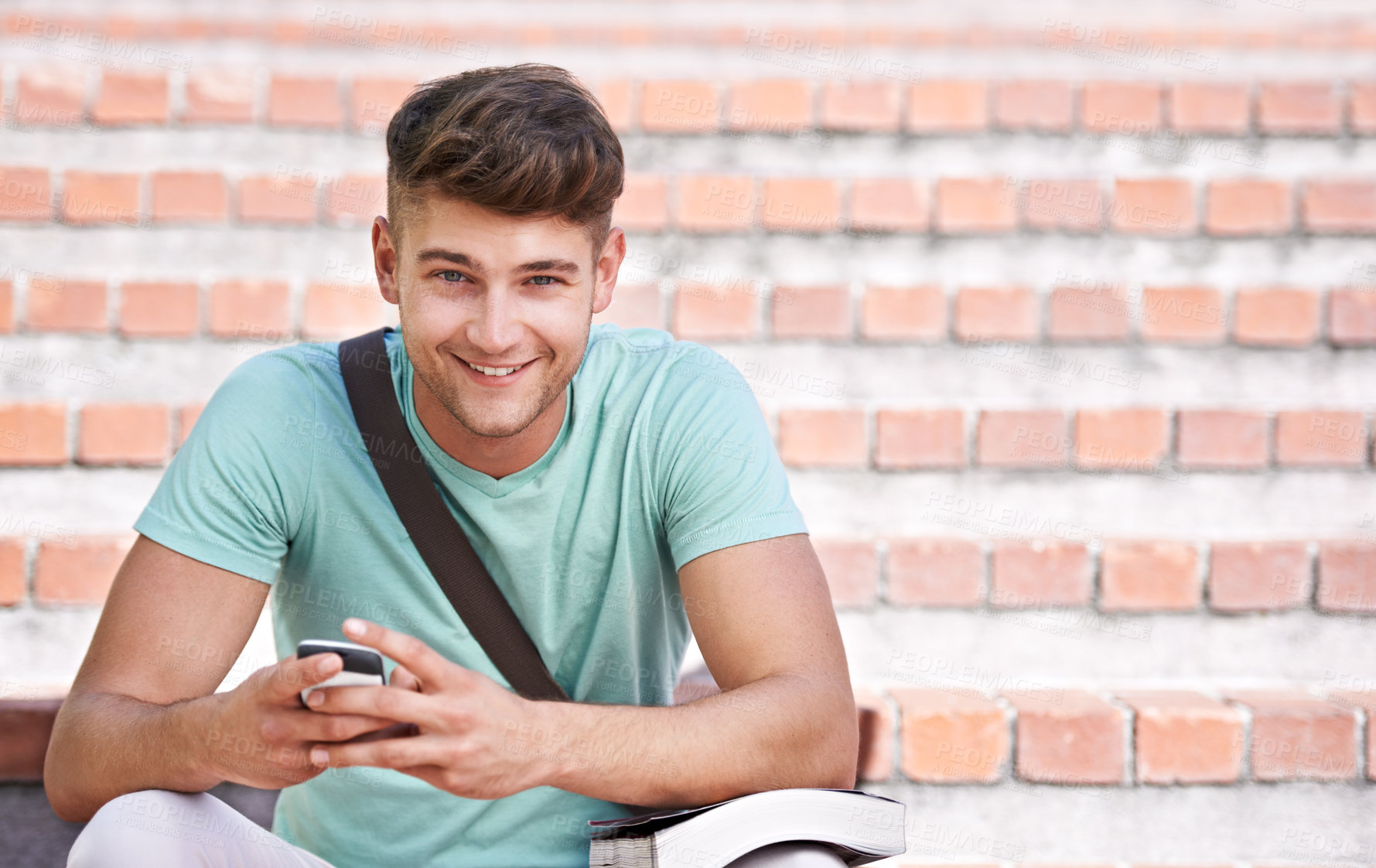 Buy stock photo A young student sitting on the stairs texting