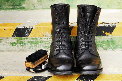 Buy stock photo Shot of a pair of polished army boots sitting on some steps