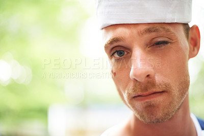 Buy stock photo Portrait, hat and man wink outdoor in sailor outfit at music festival, event or summer carnival. Face, blink and serious person at party for celebration concert, bokeh and facial paint in France