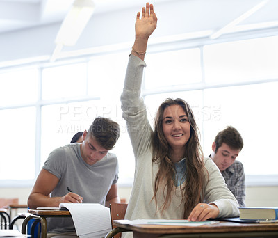 Buy stock photo Shot of a female college student in class with her arm raised to answer a question
