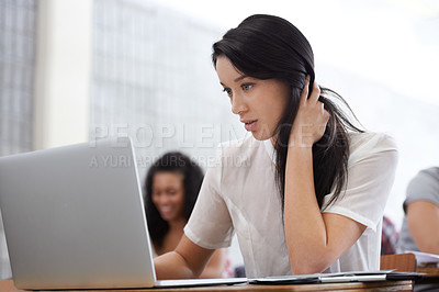Buy stock photo Shot of a bored young college student sitting at a laptop in class