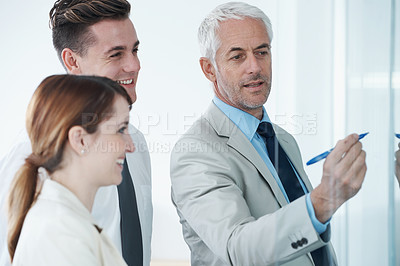 Buy stock photo Glass wall, writing and business people in a meeting, coaching and brainstorming with financial planning. Project, teamwork and manager with employees and teaching with conversation and cooperation