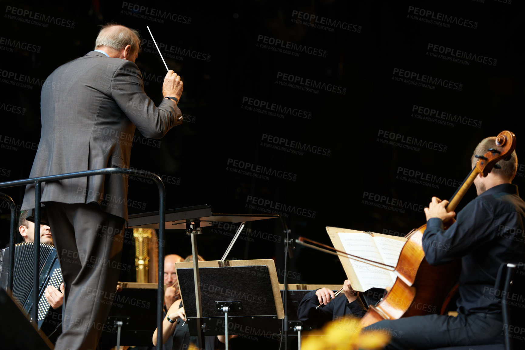 Buy stock photo Conductor, musicians and orchestra concert on stage or live music at festival for entertainment, performance or event. People, violin and playing instrument or symphony artist, behind or professional