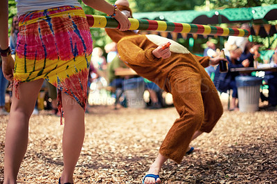 Buy stock photo Limbo, game and person at party outdoor with balance and playing at a music festival, event or challenge. Fun, people and outdoor in woods, forest or person in social activity at party in bear suit