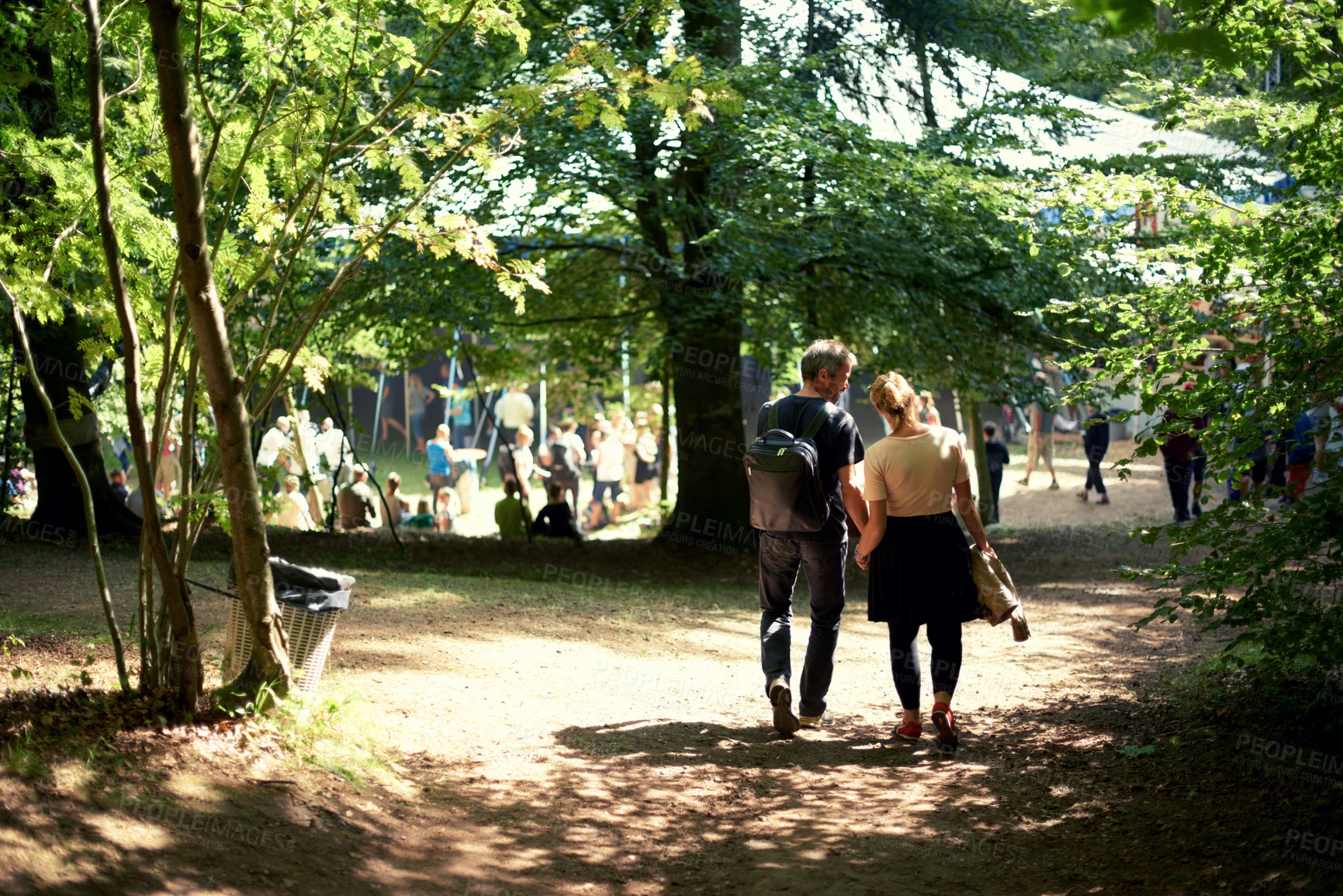 Buy stock photo Love, couple and holding hands at music festival outdoor, carnival and celebrate valentines day date. Back view, man and woman together at party, park or walk in nature for support in relationship