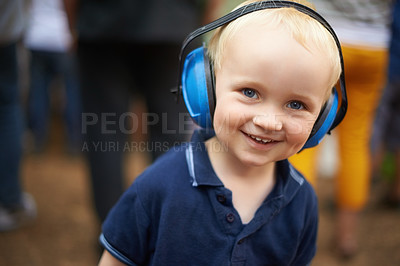 Buy stock photo Portrait, child and noise cancelling headphones at outdoor event with smile, fun and music. Protection, happiness and boy toddler at festival, concert or live performance with soundproof headset.