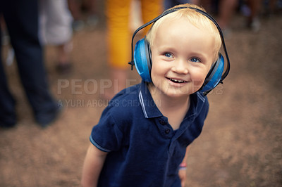 Buy stock photo Closeup shot of a young boy wearing noise canceling headphones at an outdoor festival