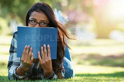 Buy stock photo Woman, student and lying with book on green grass for literature, studying or story in nature. Female person, nerd or young geek with notebook for reading, education or secret to future at the park