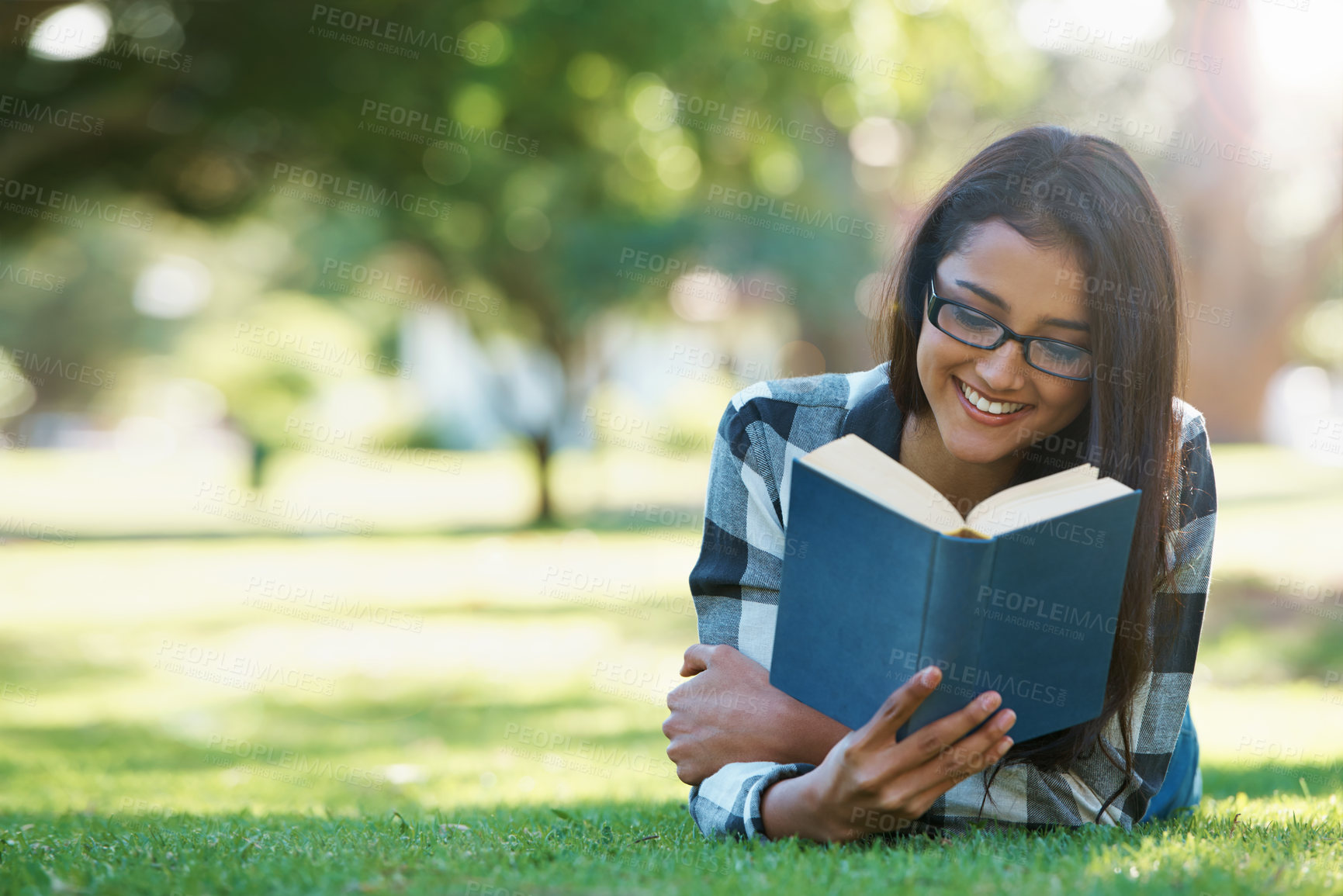 Buy stock photo Happy woman, student and reading book in nature for literature, studying or story on green grass. Female person, smart or young adult with smile or glasses for chapter, learning or outdoor education