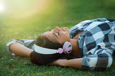Buy stock photo Music headphones, park or woman on lawn to relax for rest in garden, nature or field with smile or peace. Eyes closed, streaming or calm person on break with playlist for radio or podcast on grass