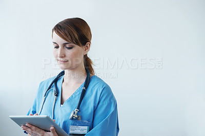 Buy stock photo A female doctor working on a digital tablet