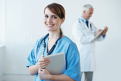 Buy stock photo A cute nurse holding a digital tablet and smiling at the camera