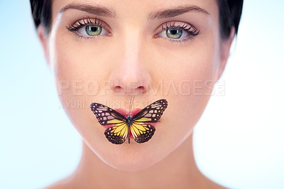 Buy stock photo Portrait, beauty and butterfly with natural woman in studio on blue background for skincare or wellness. Spa, face or lips and confident young model looking confident with skin treatment routine