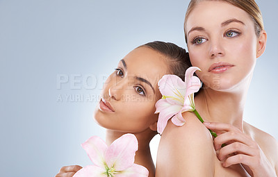 Buy stock photo Woman, skincare and flowers for natural beauty, makeup or cosmetics in relax on a blue studio background. Young female, people or models in calm satisfaction for spa or facial treatment on mockup