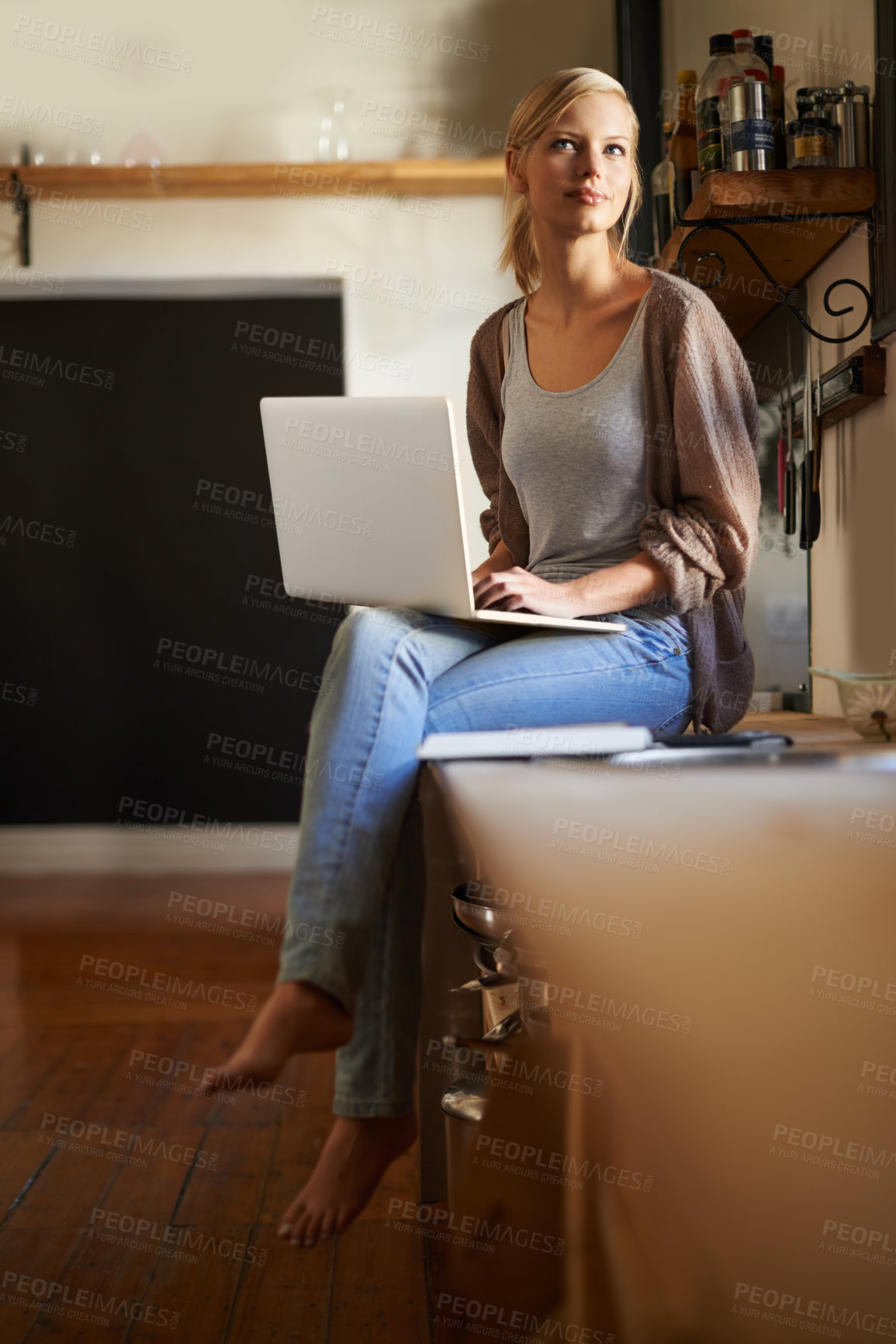 Buy stock photo Shot of an attractive young woman using her laptop while relaxing at home