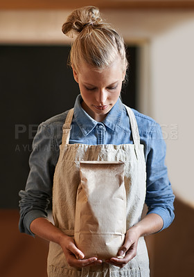 Buy stock photo Woman, barista and paper bag with apron in coffee shop, small business owner with parcel and serious for service. Catering, hospitality and entrepreneur with eco friendly package for product in store
