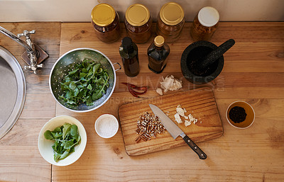 Buy stock photo Salad, knife and ingredients on kitchen counter or cooking as leafy greens or nutrition, health or wellness. Wooden board, garlic and walnuts or spices as organic with lettuce, vegetables or top view