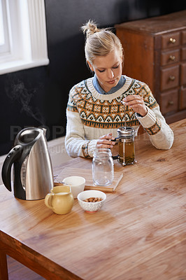 Buy stock photo Woman, kitchen and herbal tea in home for health and warm drink with plant leaf mixture for wellness. Above, designer and morning with dried leaves in plunger and calm for detox beverage in apartment