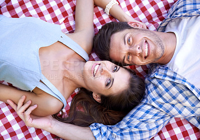 Buy stock photo Happy, couple and smile on blanket for picnic in portrait for bonding, connection and date. Man, woman and face with laying on ground for romance, vacation or love in healthy relationship from above