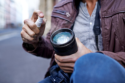 Buy stock photo Hands, man and photographer with spray for camera lens to clean for work, create portfolio in streets of Berlin. Closeup, artist and picture in public space for career in media and creativity. 