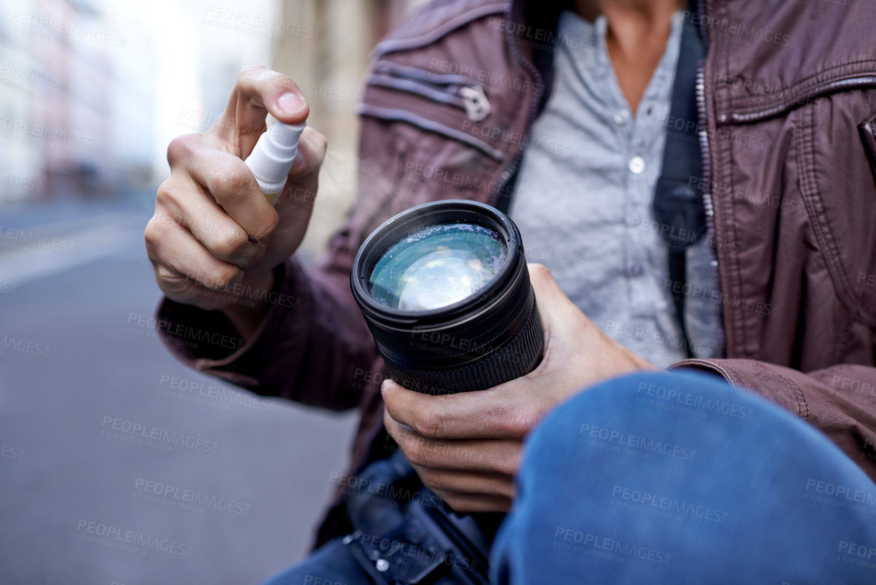Buy stock photo Hands, man and photographer with spray for camera lens to clean for work, create portfolio in streets of Berlin. Closeup, artist and picture in public space for career in media and creativity. 