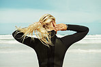 Tying back her hair for comfort during surfing