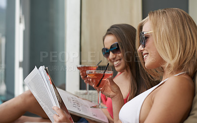 Buy stock photo Friends, women and relaxing with cocktail at resort, bonding and drinking wine on tropical vacation. People, reading news and magazine for gossip on summer holiday, weekend trip and travel to retreat