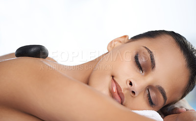 Buy stock photo Relax, hot stone and woman with massage at spa for wellness, health and back treatment. Self care, cosmetic and young female person sleeping for warm stone back therapy at natural beauty salon.