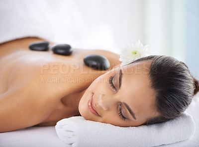 Buy stock photo Calm, hot stone and woman with massage at spa for wellness, health and back treatment. Self care, cosmetic and young female person sleeping for warm stone back therapy at natural beauty salon.