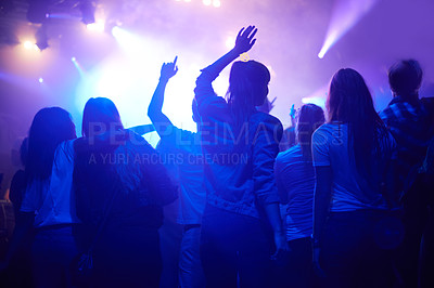 Buy stock photo Purple, neon light and people dancing at music festival from back, night and energy at live concert event. Dance, fun and group of excited fans in arena at rock band performance or crowd at party.
