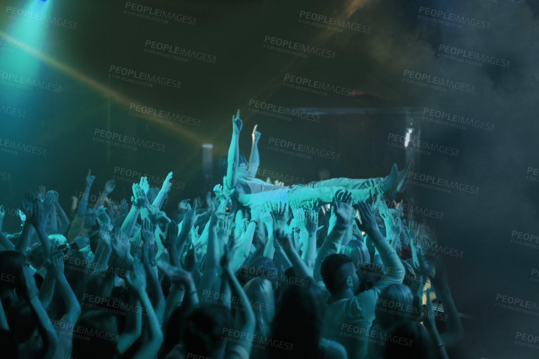 Buy stock photo Crowd surf, blue light and people at concert or at music festival, lights and energy at live event. Dance, fun and group of excited fans in arena at rock show performance, group carrying fan on hands