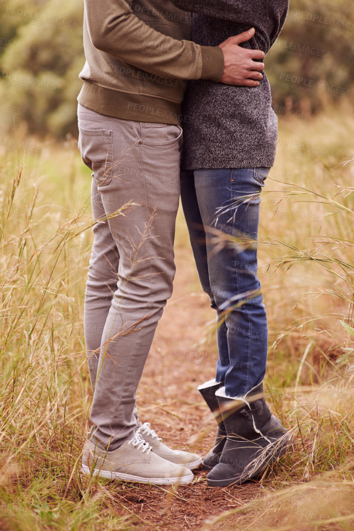 Buy stock photo Love, legs and hug with couple in countryside together for romance, bonding or dating on field of grass. Nature, earth or environment with man and woman embracing outdoor for anniversary closeup