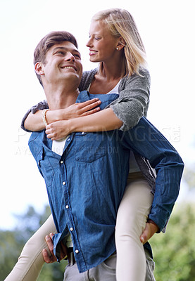 Buy stock photo A young woman recieving a piggyback ride from her boyfriend