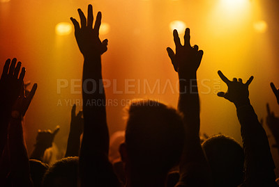 Buy stock photo Orange lights, hands of people at concert or music festival dancing with energy in silhouette at live event. Dance, fun and group of excited fans in arena at rock band performance or crowd at party.