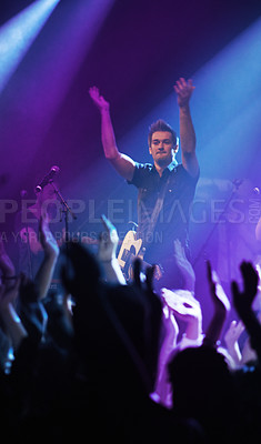 Buy stock photo People hands, music and singer at concert in night performance, rock band or gen z in neon lights or cheers. Musician man on stage at disco event and fans clapping, crowd or audience dancing on floor
