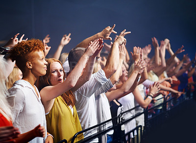Buy stock photo Crowd in fence row, fans at music festival or concert watching rock event on stage. Excited people in audience at band performance at arena, stadium or party with applause and energy at night show.