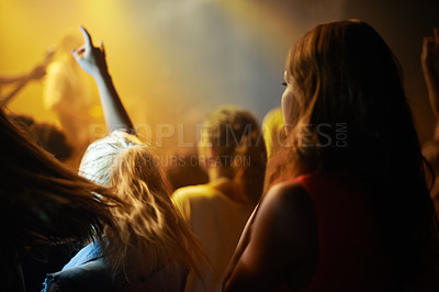 Buy stock photo Back of woman in crowd, fan at concert or music festival watching rock event on stage. Girl in audience, excited fans at live band performance in arena or stadium with lights and energy at night show