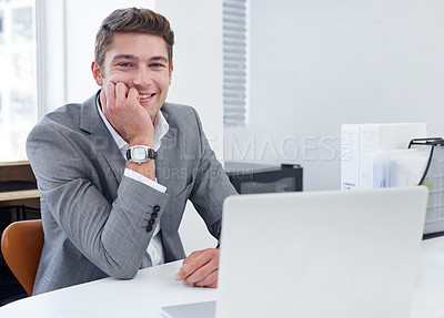 Buy stock photo A satisfied young businessman sitting at his desk