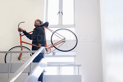 Buy stock photo Bicycle, stairs and man carrying bike for exercise and eco friendly transportation with travel. Staircase, carbon neutral and cyclist with apartment complex and journey of walking steps in building